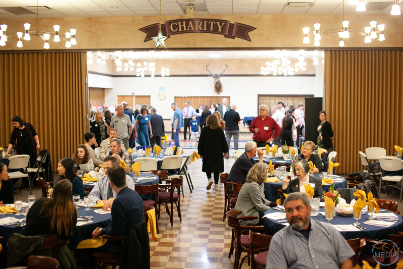 Members and participants of various Optimist Club of Reno programs, seated at banquest tables.
